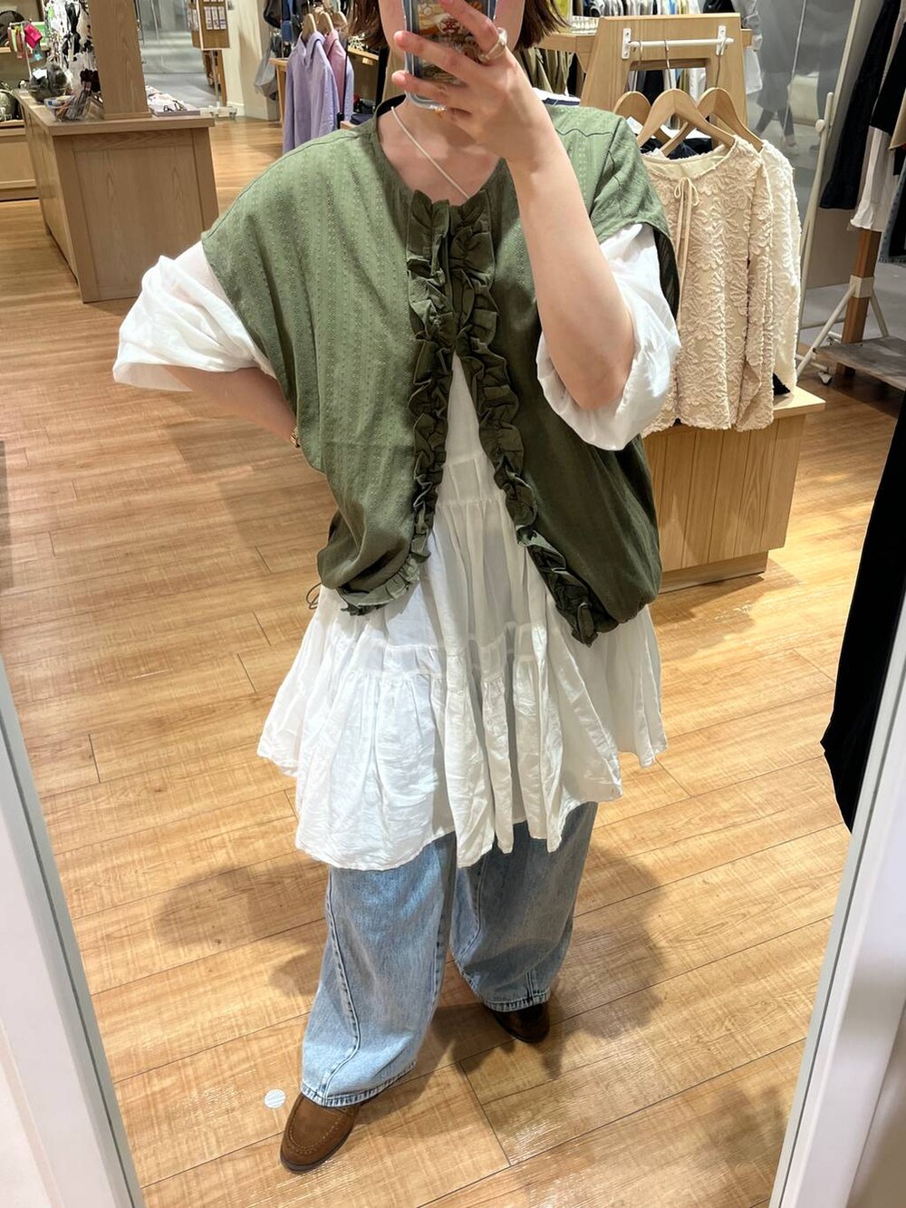 ブルー系のデニムパンツ、ブラウン系のトートバッグ、ホワイト系のシャツ/ブラウスを着用したレディースの春コーディネートの5枚目の写真