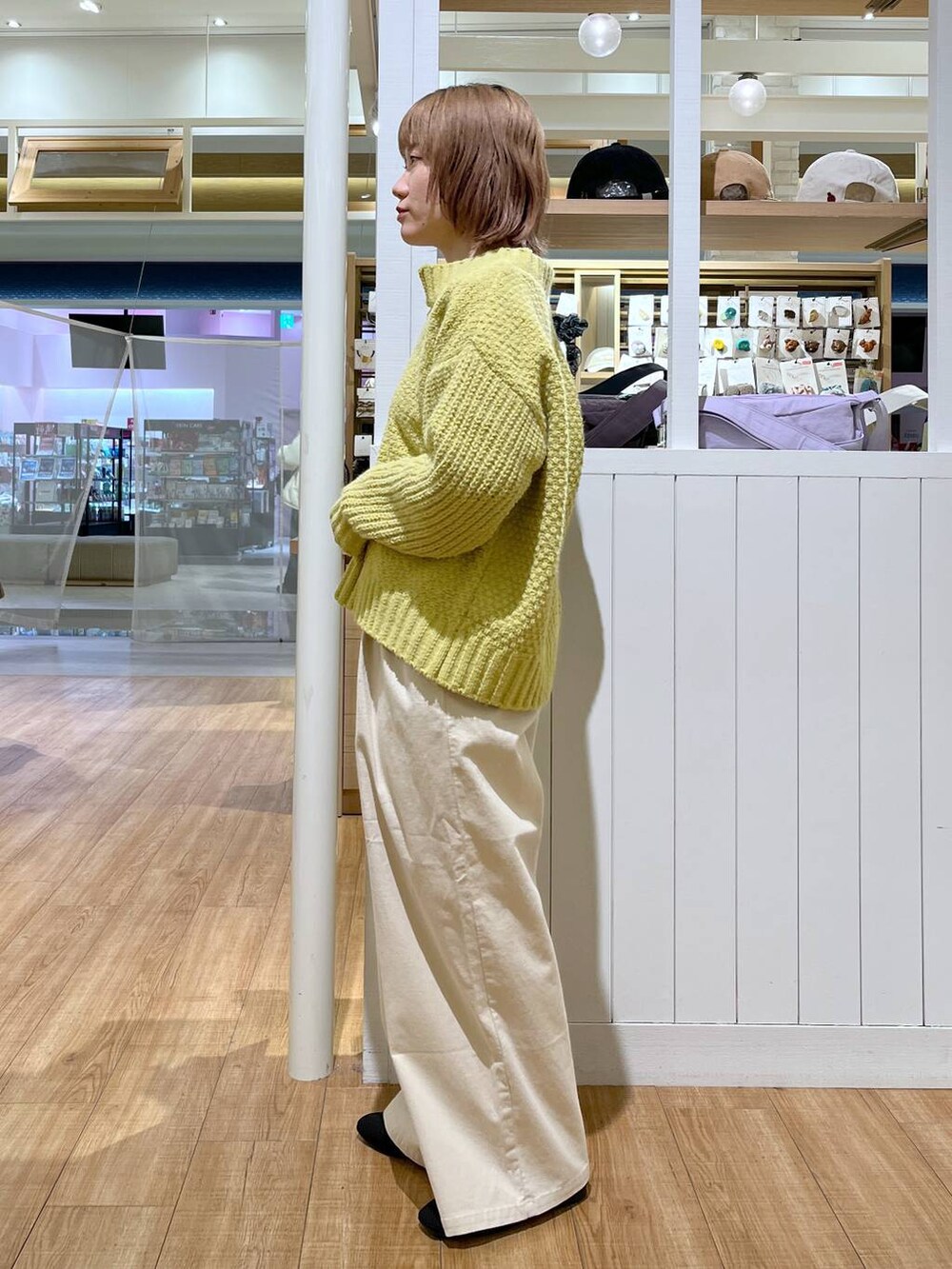 ベージュ系のその他パンツ、イエロー系のニット/セーター、ブラック系のパンプスを着用したレディースの冬コーディネートの5枚目の写真