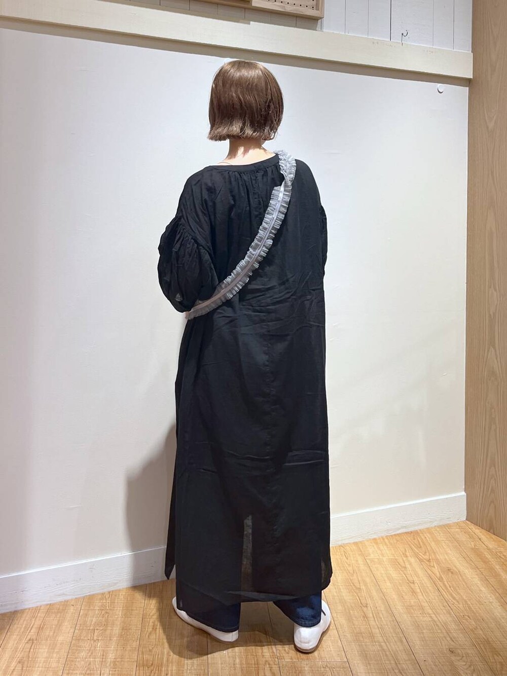 ホワイト系のパンプス、ブラック系のワンピース、グレー系のスマホグッズを着用したレディースの秋コーディネートの5枚目の写真