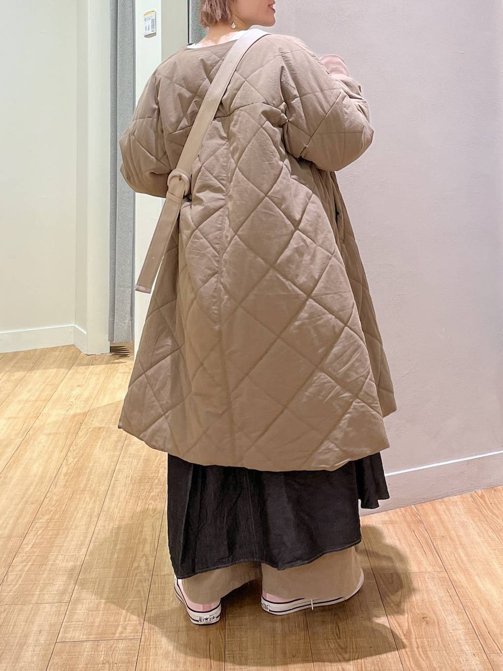 ブラック系のワンピース、ベージュ系のモッズコート、ベージュ系のショルダーバッグを着用したレディースの春コーディネートの3枚目の写真