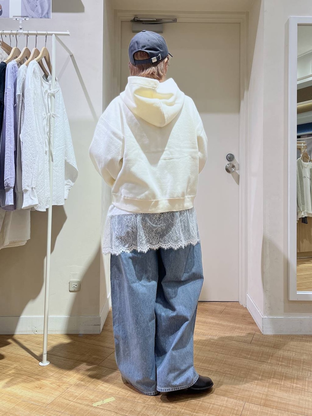 ブルー系のデニムパンツ、ホワイト系のパーカー、ホワイト系のTシャツ/カットソーを着用したレディースの春コーディネートの4枚目の写真