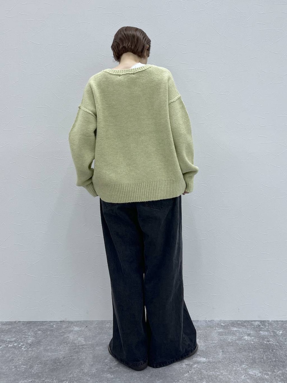 ブラック系のデニムパンツ、イエロー系のその他アウター、グレー系のモカシン/デッキシューズを着用したレディースの秋コーディネートの7枚目の写真