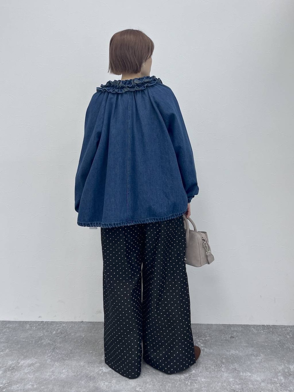 ブルー系のブルゾン、ブラウン系のパンプス、ホワイト系のシャツ/ブラウスを着用したレディースの春コーディネートの3枚目の写真