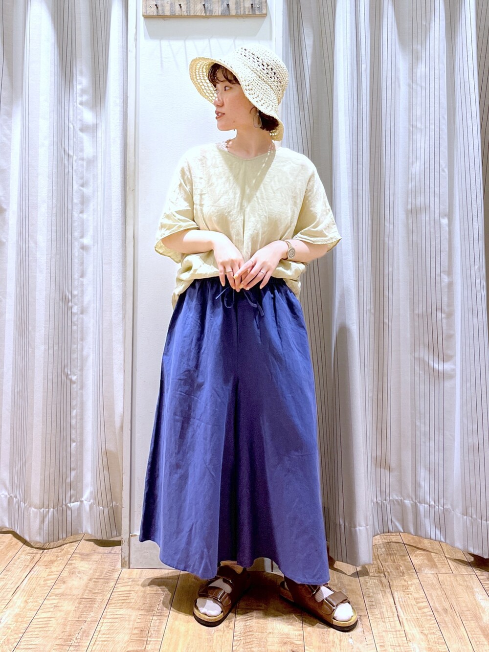 イエロー系のシャツ/ブラウス、ブルー系のその他パンツ、ブラウン系のサンダルを着用したレディースの夏コーディネートの2枚目の写真