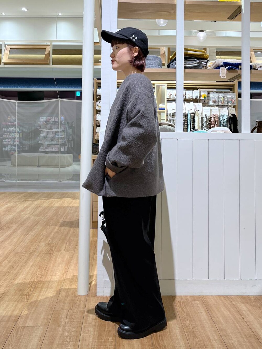 グレー系のスウェット、ブラック系のサロペット/オーバーオール、ブラック系のブーツを着用したレディースの秋コーディネートの2枚目の写真