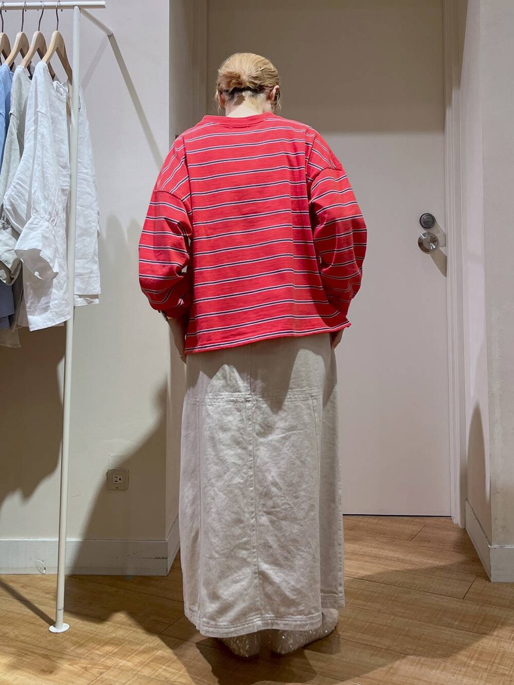 レッド系のTシャツ/カットソー、ホワイト系のバレエシューズ、ベージュ系のカーディガン/ボレロを着用したレディースの春コーディネートの6枚目の写真