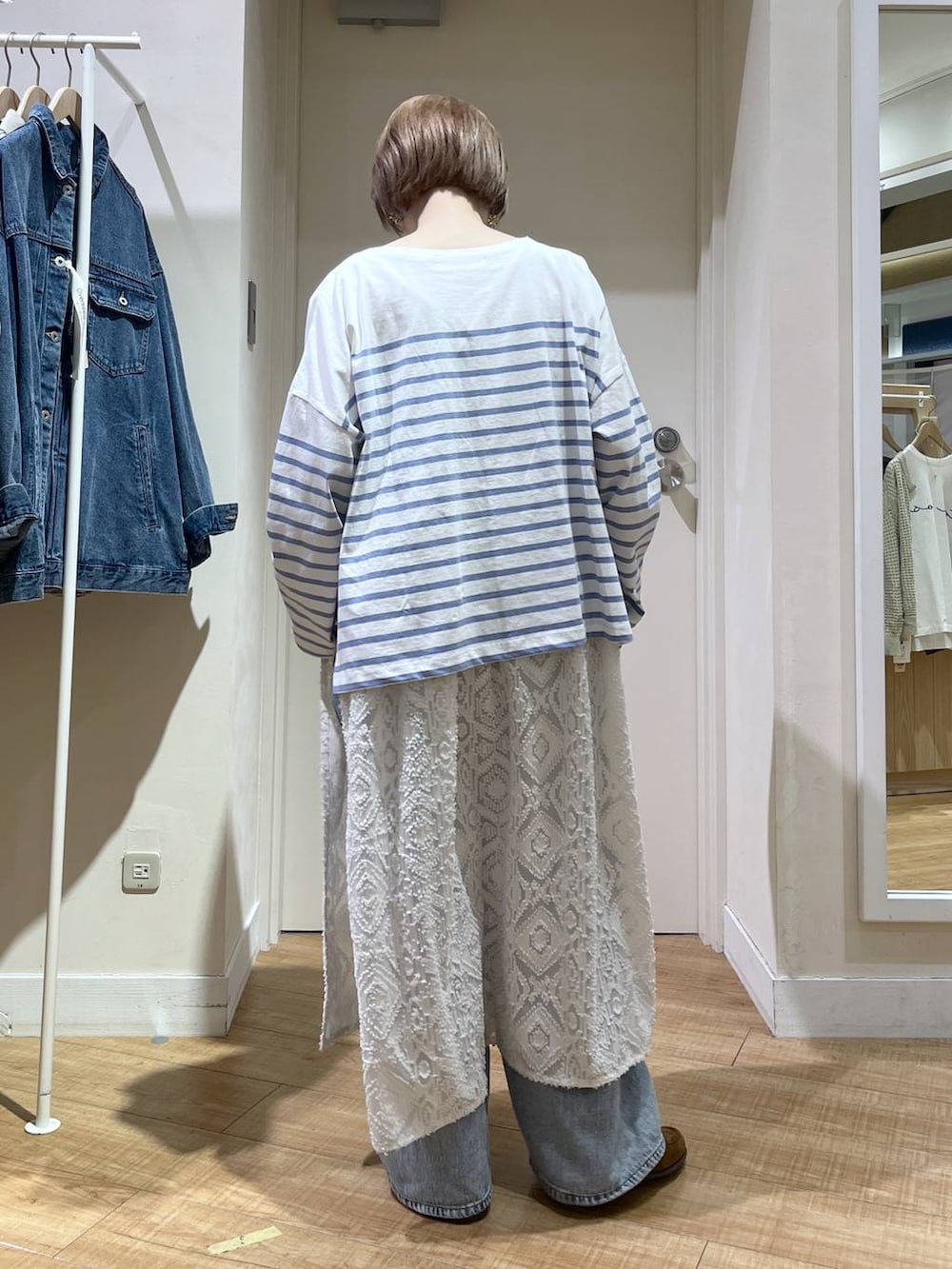 ブルー系のデニムパンツ、ブルー系のブルゾン、ホワイト系のベストを着用したレディースの春コーディネートの6枚目の写真