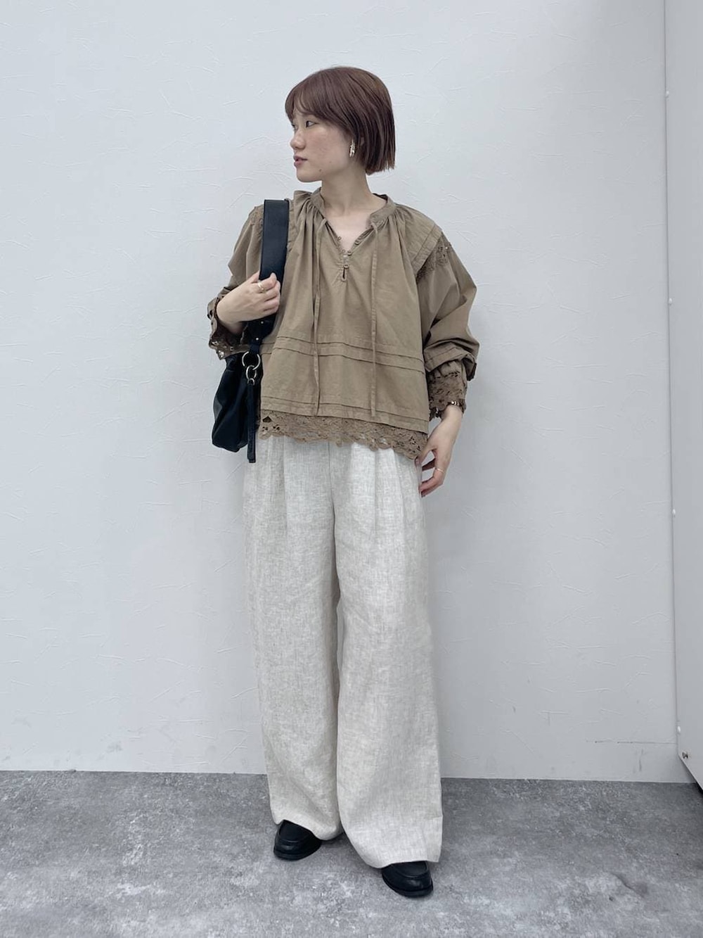 ブラック系のトートバッグ、ブラック系のローファー、ベージュ系のシャツ/ブラウスを着用したレディースの春コーディネートの4枚目の写真