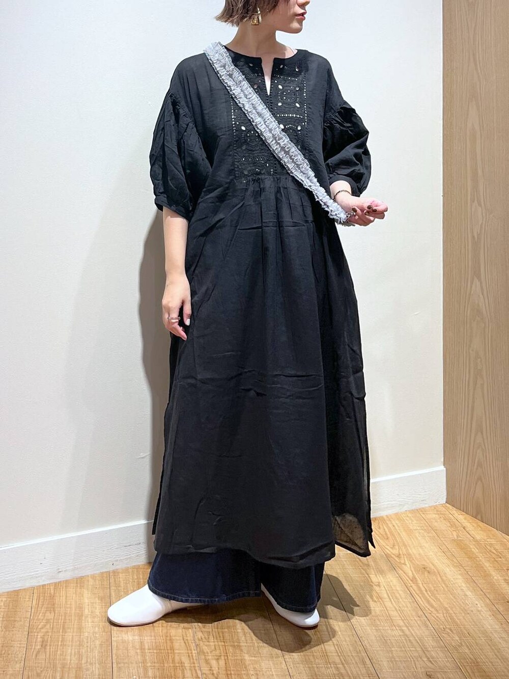 ホワイト系のパンプス、ブラック系のワンピース、グレー系のスマホグッズを着用したレディースの秋コーディネートの3枚目の写真