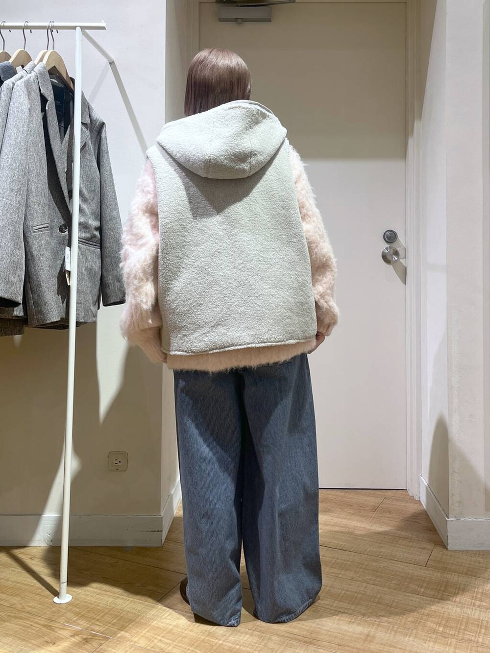 ブラウン系のベスト、ピンク系のニット/セーター、ブルー系のデニムパンツを着用したレディースの冬コーディネートの4枚目の写真