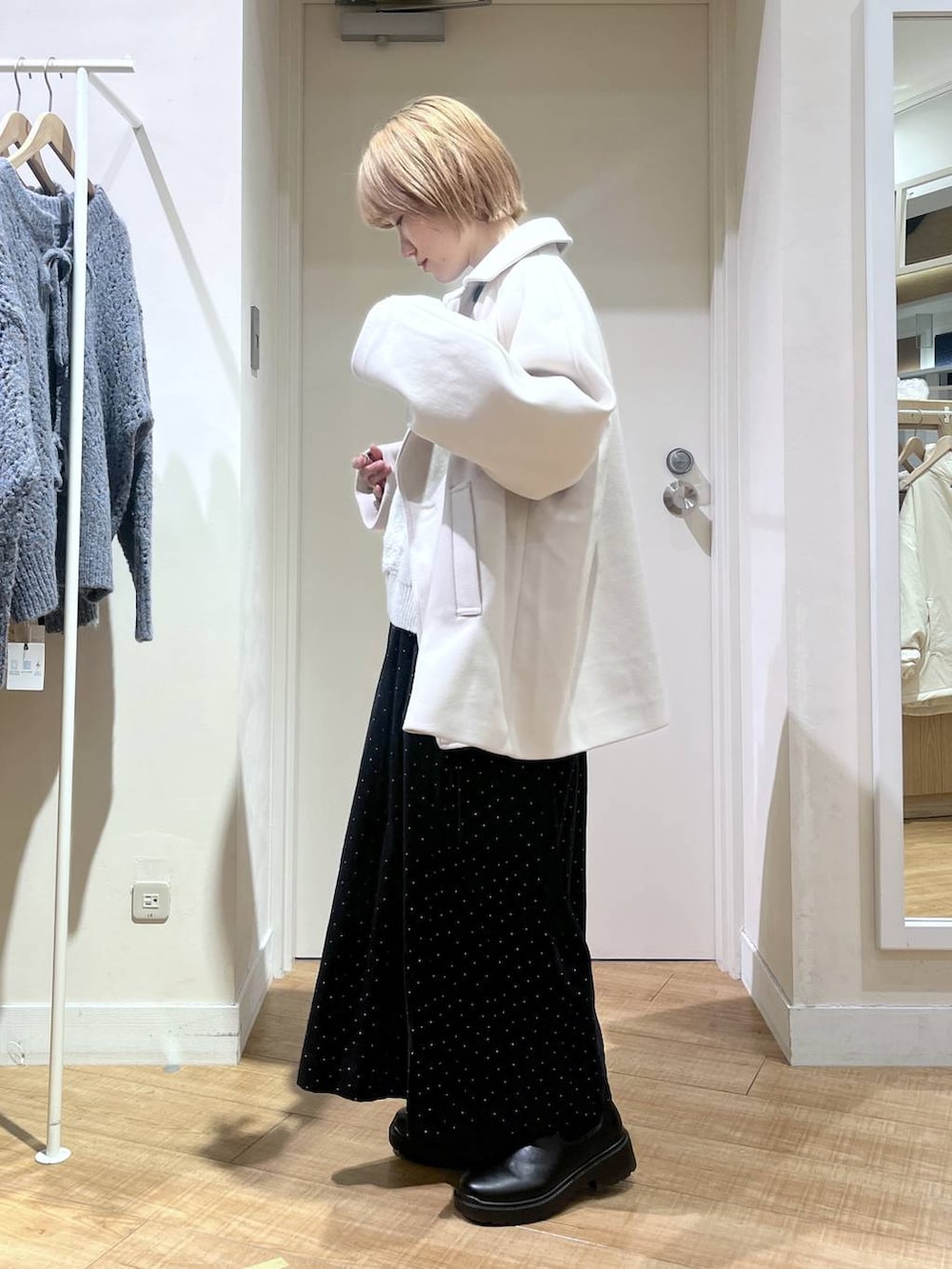 ホワイト系のピーコート、グレー系のニット/セーター、その他のその他パンツを着用したレディースの秋コーディネートの2枚目の写真