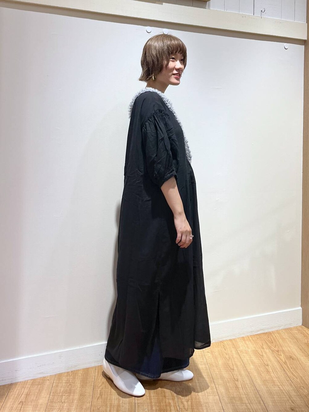 ホワイト系のパンプス、ブラック系のワンピース、グレー系のスマホグッズを着用したレディースの秋コーディネートの2枚目の写真