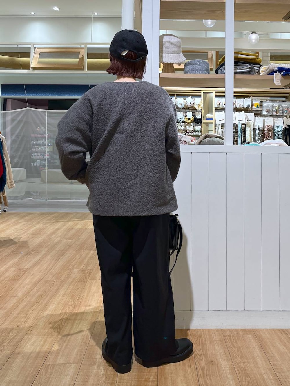 グレー系のスウェット、ブラック系のサロペット/オーバーオール、ブラック系のブーツを着用したレディースの秋コーディネートの3枚目の写真