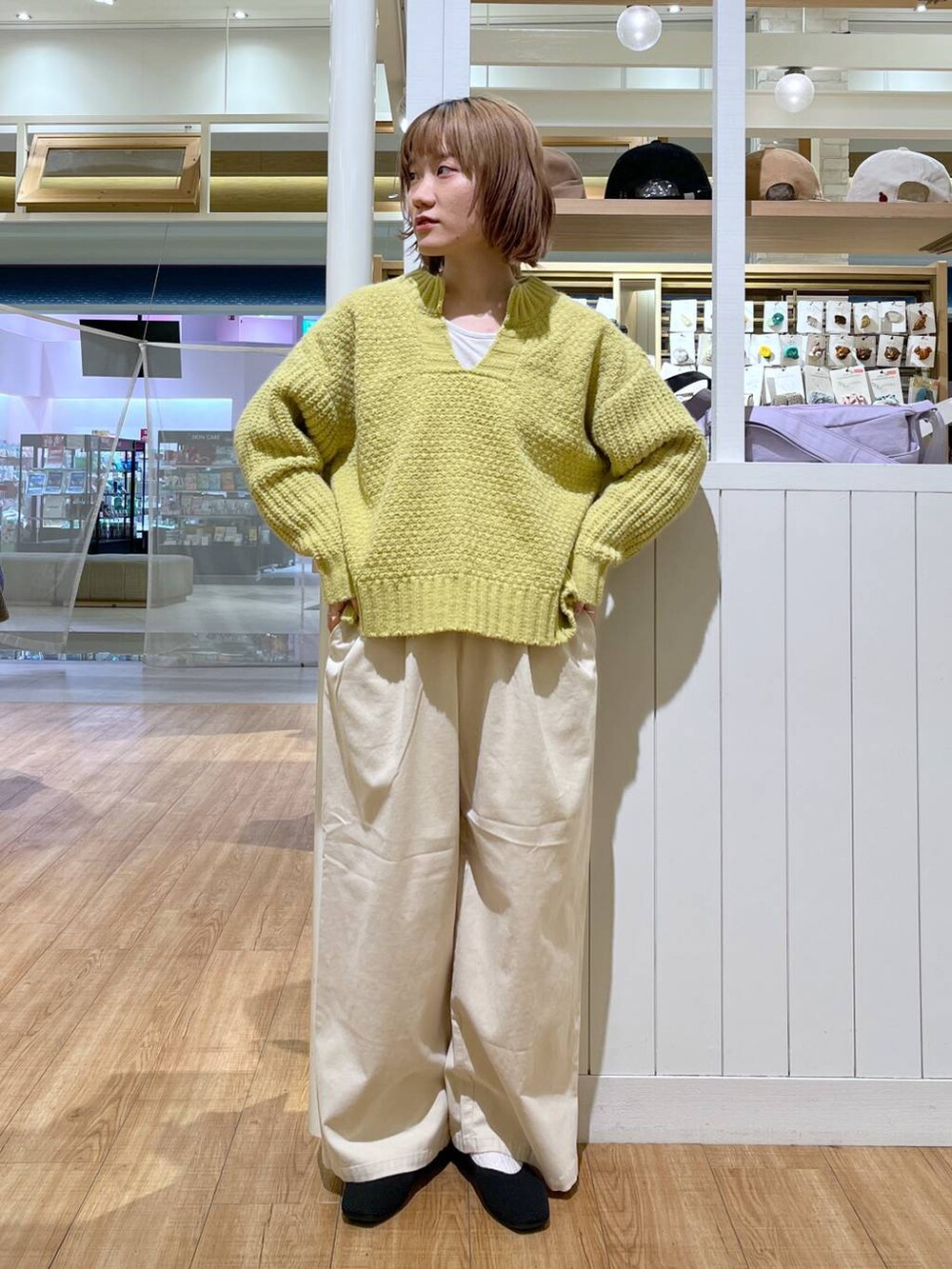 ベージュ系のその他パンツ、イエロー系のニット/セーター、ブラック系のパンプスを着用したレディースの冬コーディネートの4枚目の写真