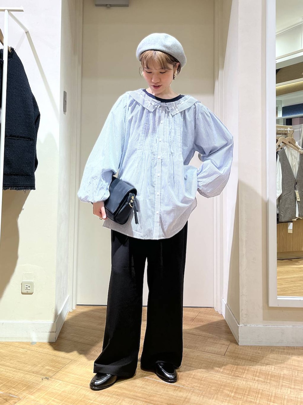 ブルー系のTシャツ/カットソー、ブラック系のスラックス、ブラック系のショルダーバッグを着用したレディースの冬コーディネートの2枚目の写真