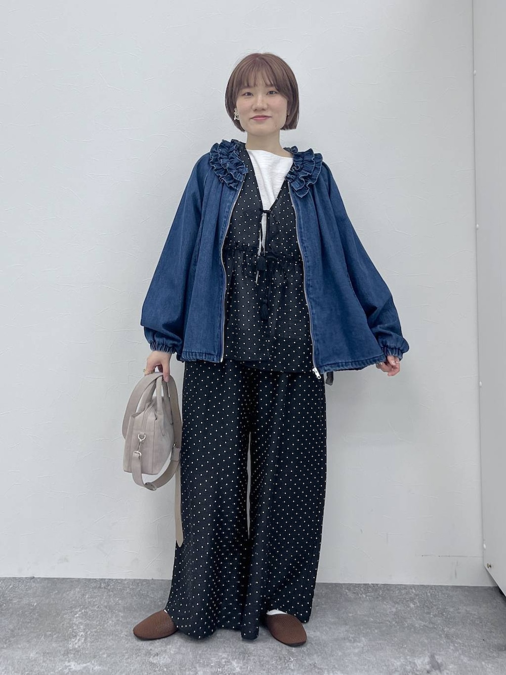 ブルー系のブルゾン、ブラウン系のパンプス、ホワイト系のシャツ/ブラウスを着用したレディースの春コーディネートの4枚目の写真