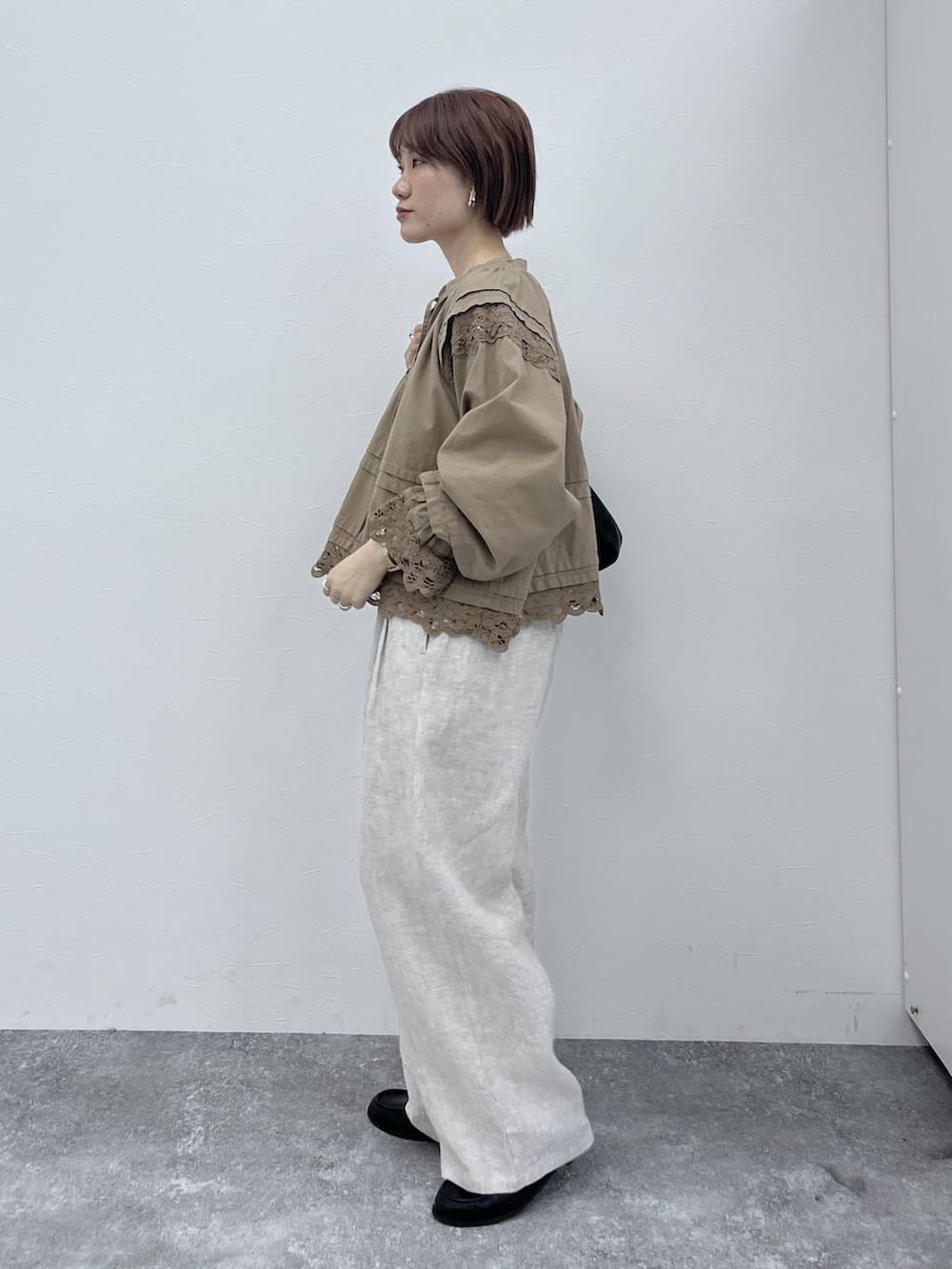 ブラック系のトートバッグ、ブラック系のローファー、ベージュ系のシャツ/ブラウスを着用したレディースの春コーディネートの2枚目の写真