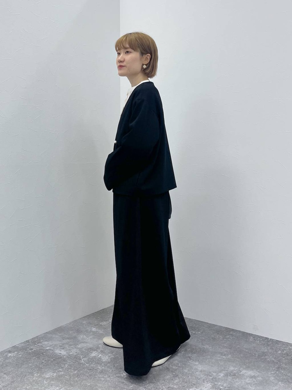 ブラック系のスーツセット、ホワイト系のシャツ/ブラウスを着用したレディースの秋コーディネートの3枚目の写真