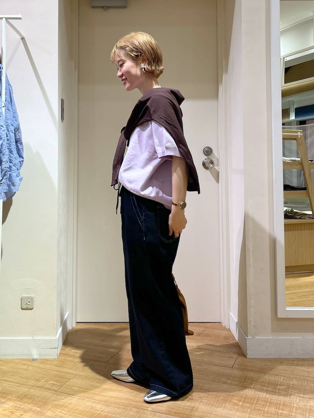 ブルー系のデニムパンツ、パープル系のスウェット、ブラウン系のショルダーバッグを着用したレディースの秋コーディネートの2枚目の写真