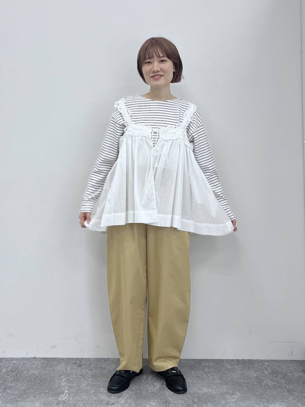 ホワイト系のベスト、ブラック系のローファー、その他のTシャツ/カットソーを着用したレディースの春コーディネートの4枚目の写真