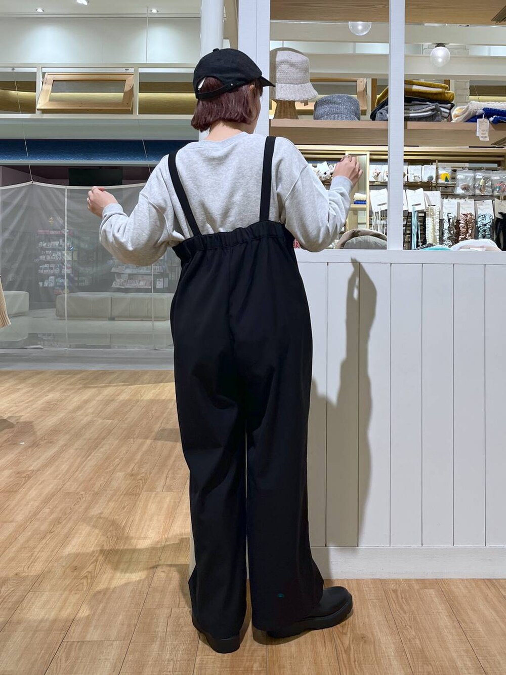 グレー系のスウェット、ブラック系のサロペット/オーバーオール、ブラック系のブーツを着用したレディースの秋コーディネートの6枚目の写真