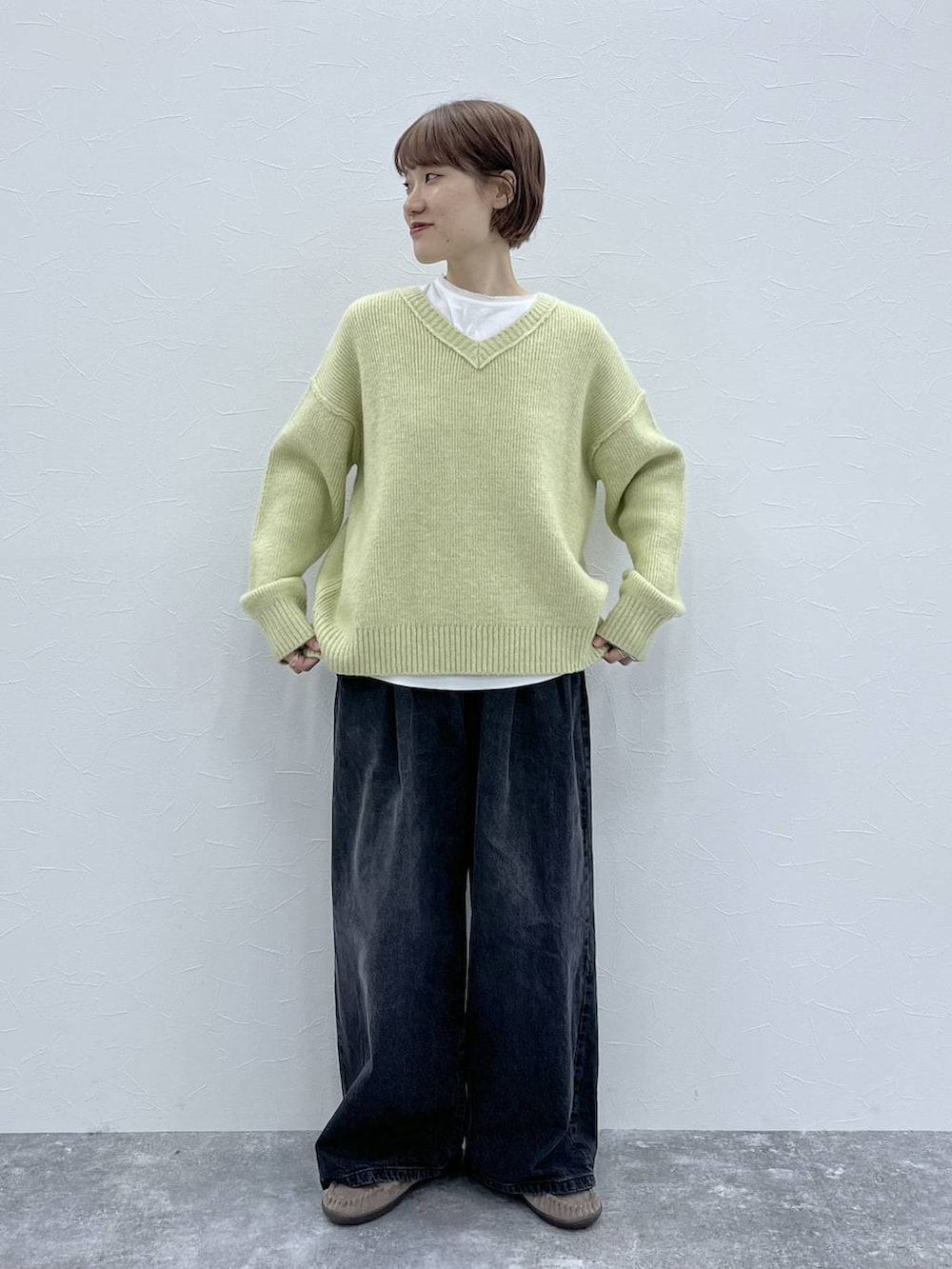 ブラック系のデニムパンツ、イエロー系のその他アウター、グレー系のモカシン/デッキシューズを着用したレディースの秋コーディネートの5枚目の写真