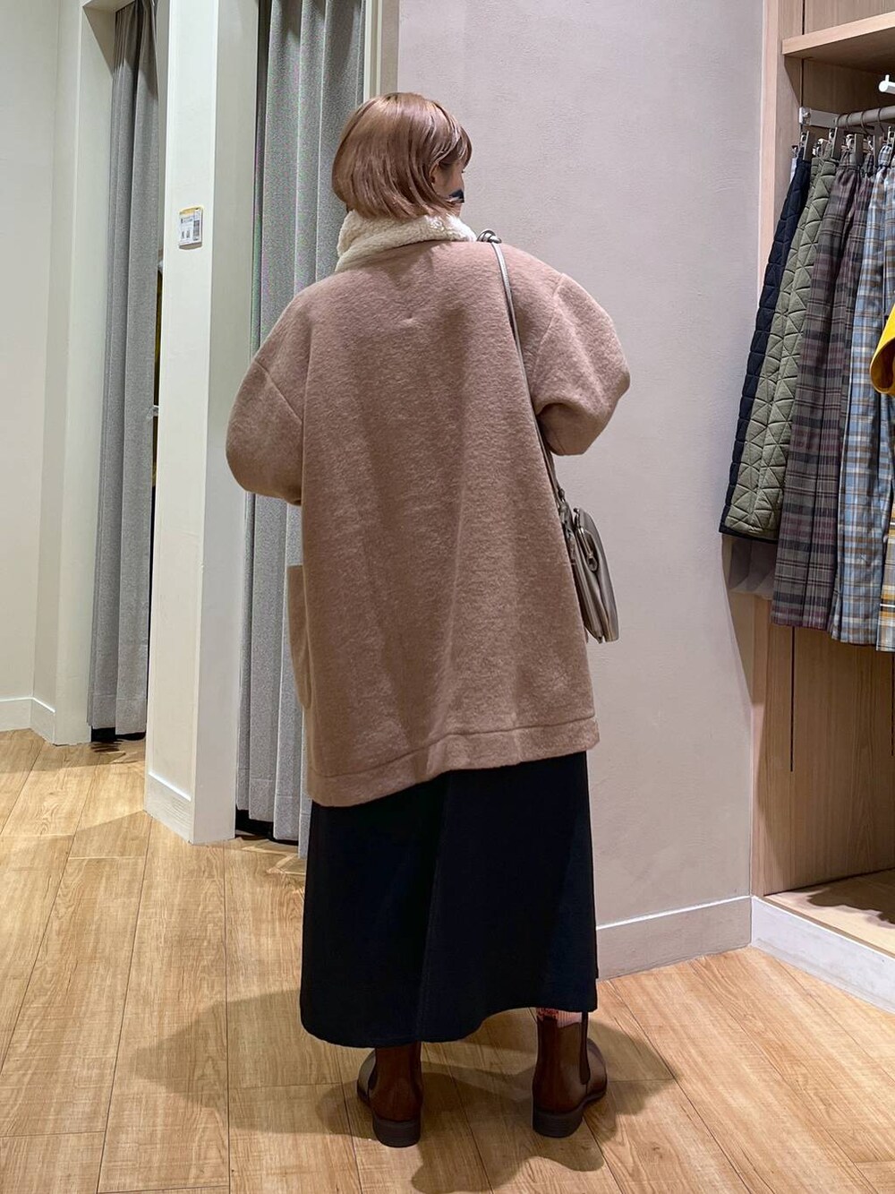 ブラウン系のブーツ、ブラウン系のノーカラージャケット、ベージュ系のニット/セーターを着用したレディースの冬コーディネートの3枚目の写真