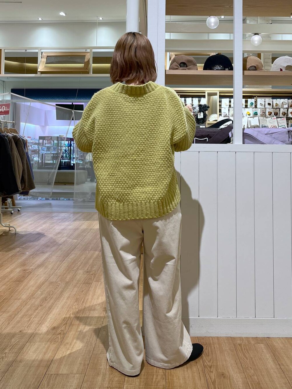 ベージュ系のその他パンツ、イエロー系のニット/セーター、ブラック系のパンプスを着用したレディースの冬コーディネートの6枚目の写真