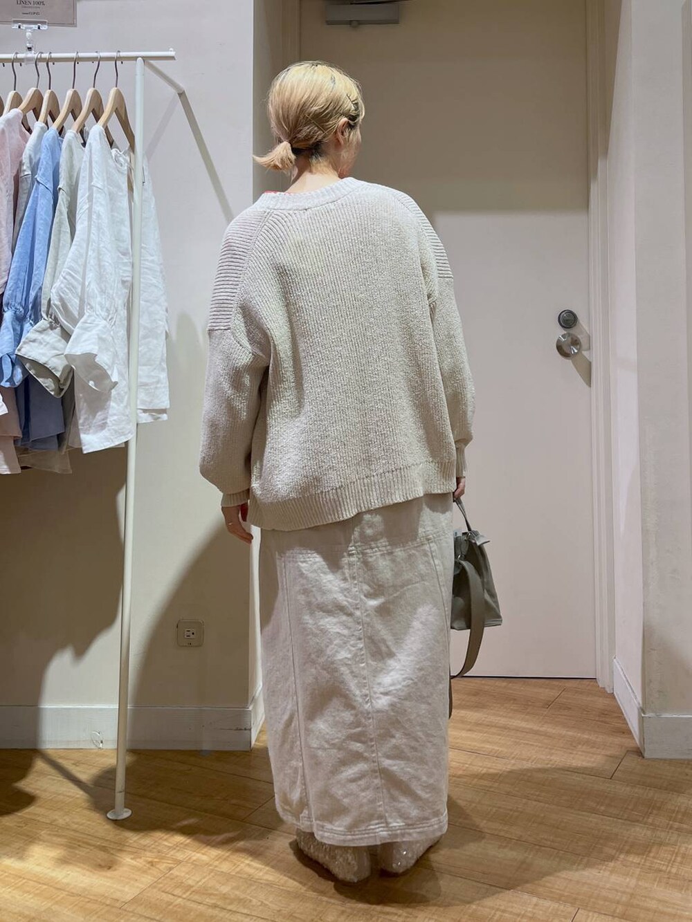 レッド系のTシャツ/カットソー、ホワイト系のバレエシューズ、ベージュ系のカーディガン/ボレロを着用したレディースの春コーディネートの3枚目の写真