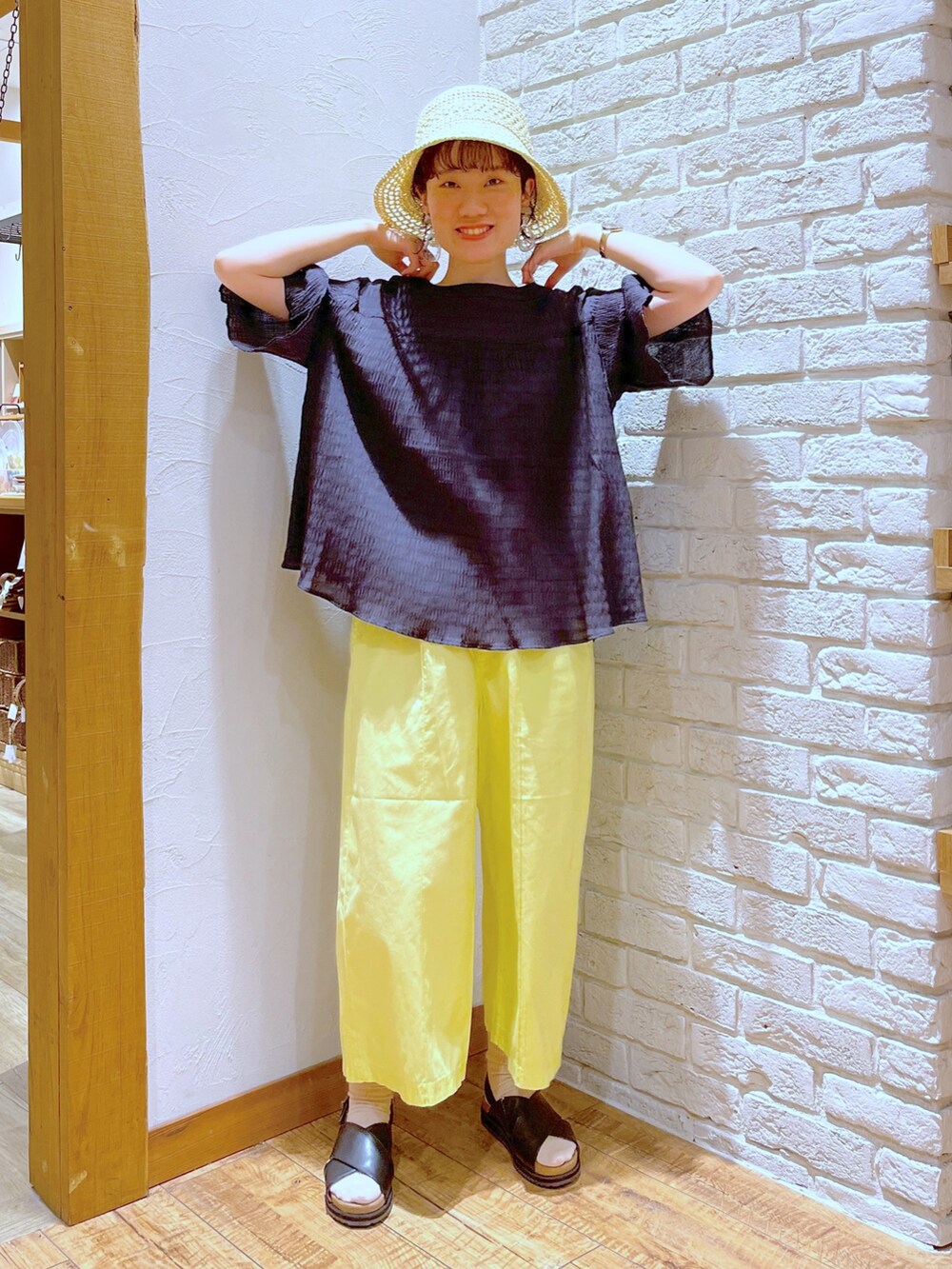 ブラック系のシャツ/ブラウス、イエロー系のその他パンツ、ブラウン系のショルダーバッグを着用したレディースの春コーディネートの2枚目の写真