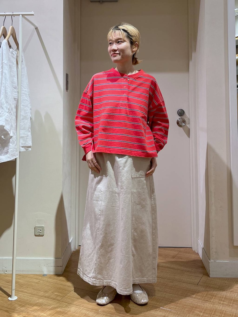 レッド系のTシャツ/カットソー、ホワイト系のバレエシューズ、ベージュ系のカーディガン/ボレロを着用したレディースの春コーディネートの4枚目の写真