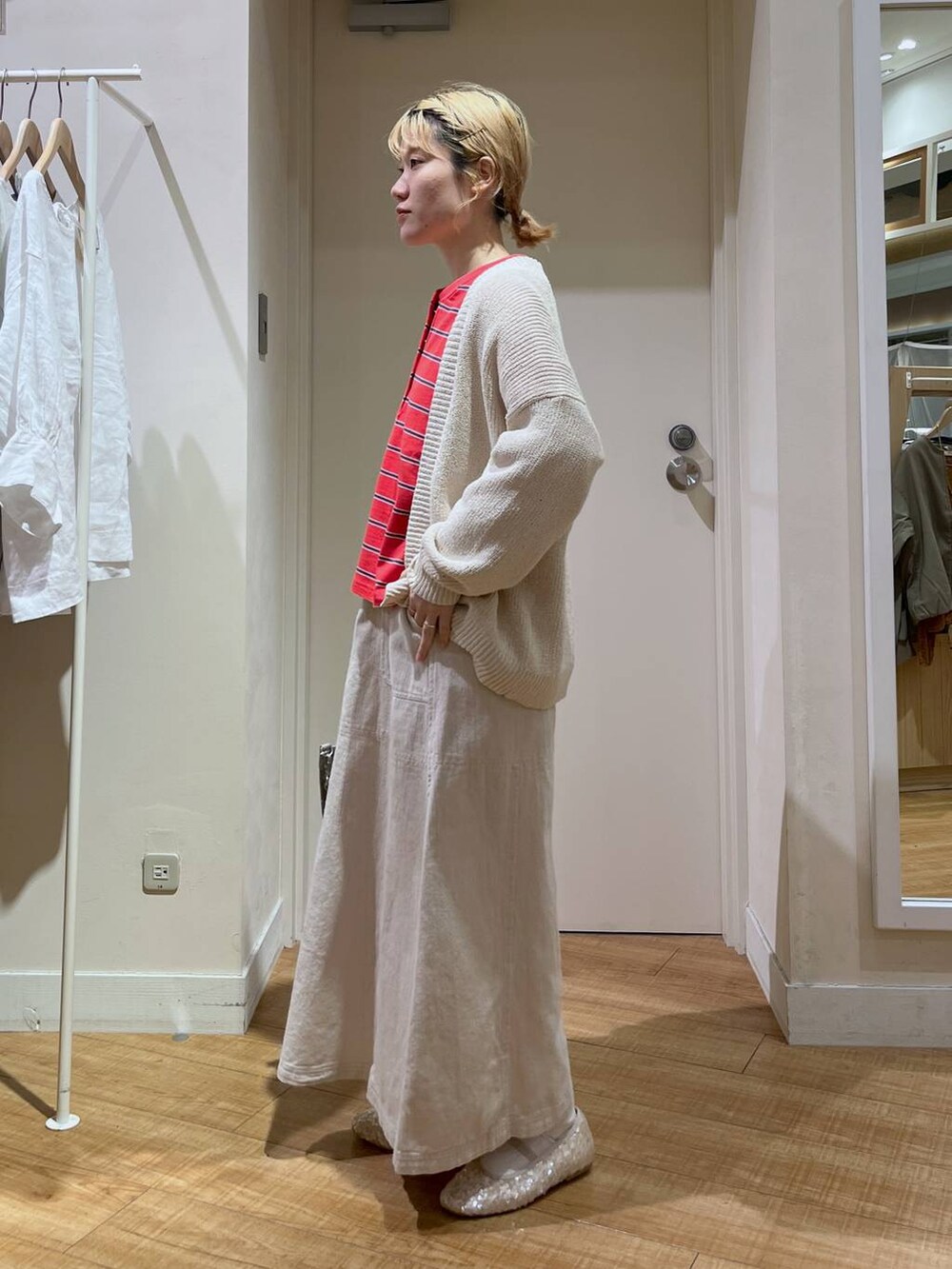 レッド系のTシャツ/カットソー、ホワイト系のバレエシューズ、ベージュ系のカーディガン/ボレロを着用したレディースの春コーディネートの2枚目の写真