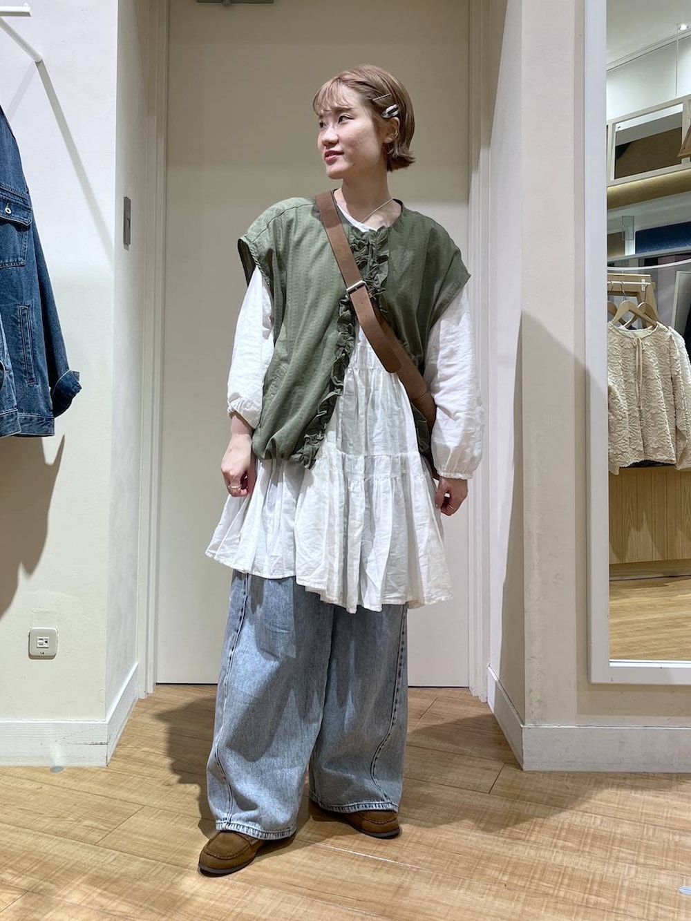 ブルー系のデニムパンツ、ブラウン系のトートバッグ、ホワイト系のシャツ/ブラウスを着用したレディースの春コーディネートの4枚目の写真