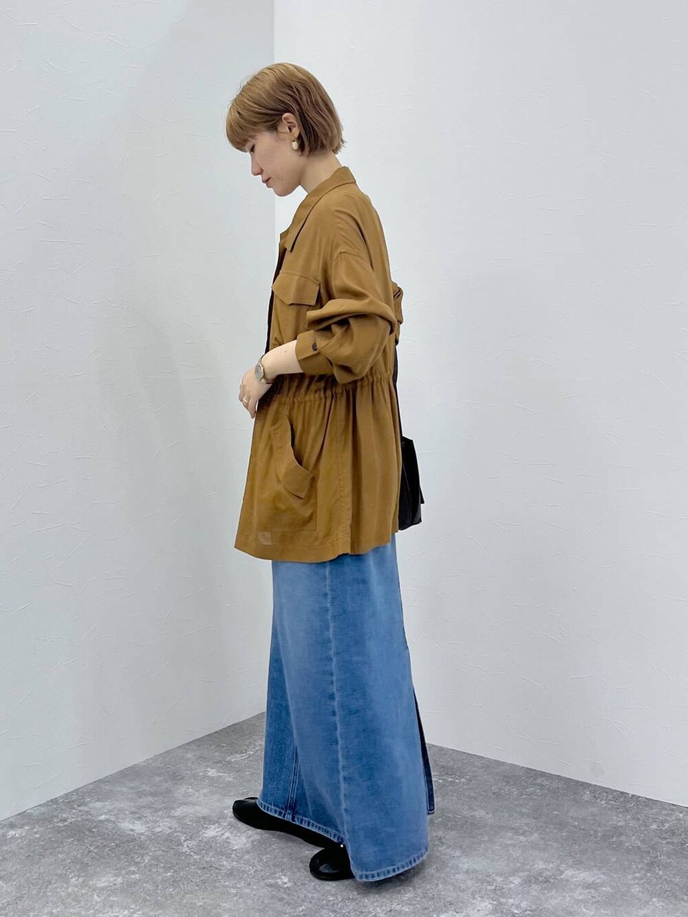 ブルー系のデニムスカート、ブラウン系のブルゾンを着用したレディースの秋コーディネートの3枚目の写真