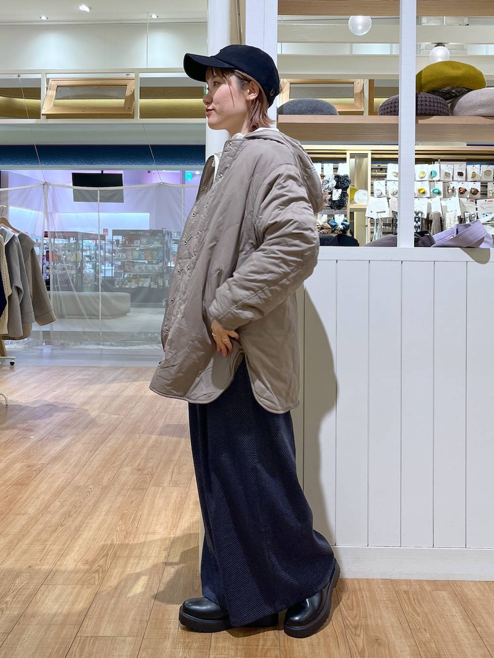 ブラウン系のブルゾン、ホワイト系のTシャツ/カットソー、ブラック系のブーツを着用したレディースの冬コーディネートの2枚目の写真