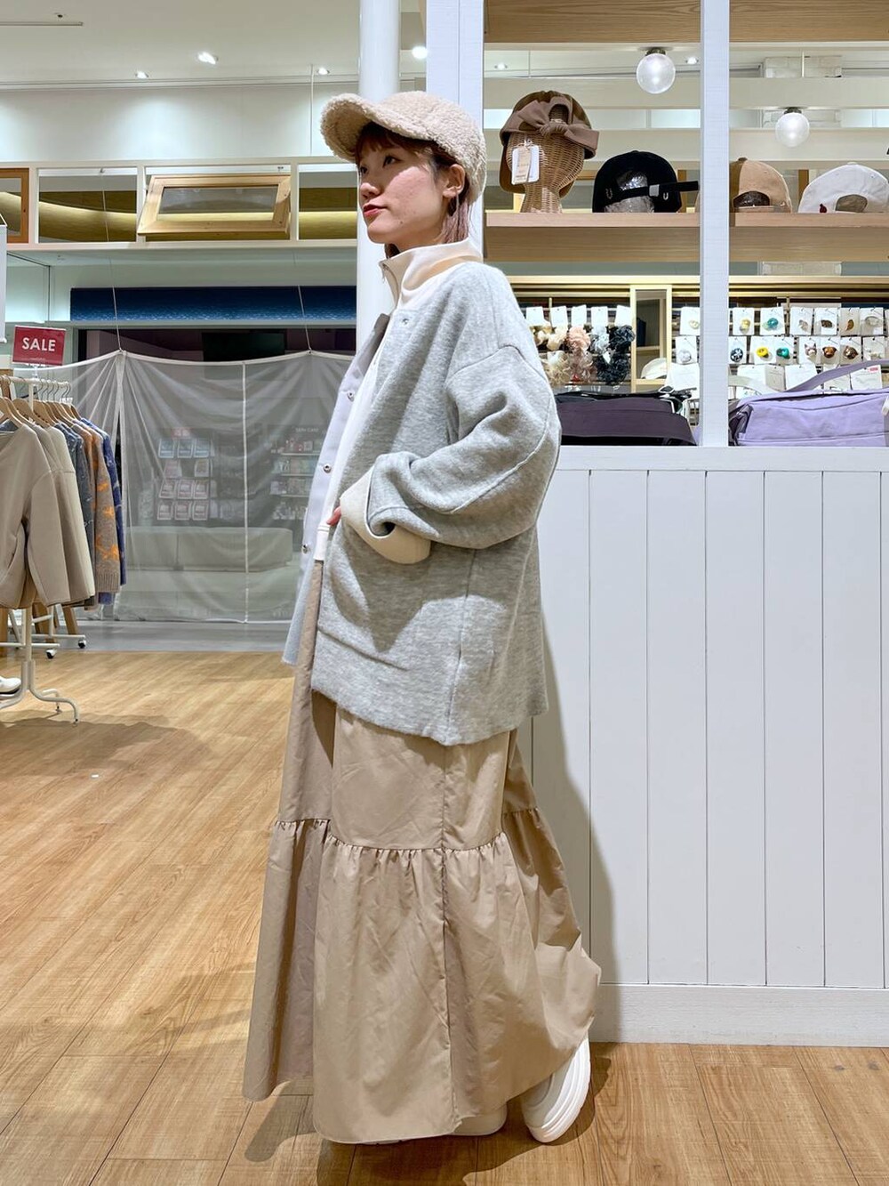ホワイト系のスリッポン、グレー系のノーカラーコート、ベージュ系のワンピースを着用したレディースの冬コーディネートの2枚目の写真