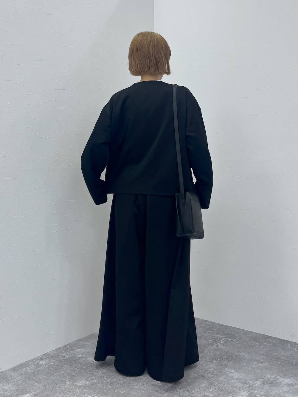 ブラック系のスーツセット、ホワイト系のシャツ/ブラウスを着用したレディースの秋コーディネートの4枚目の写真