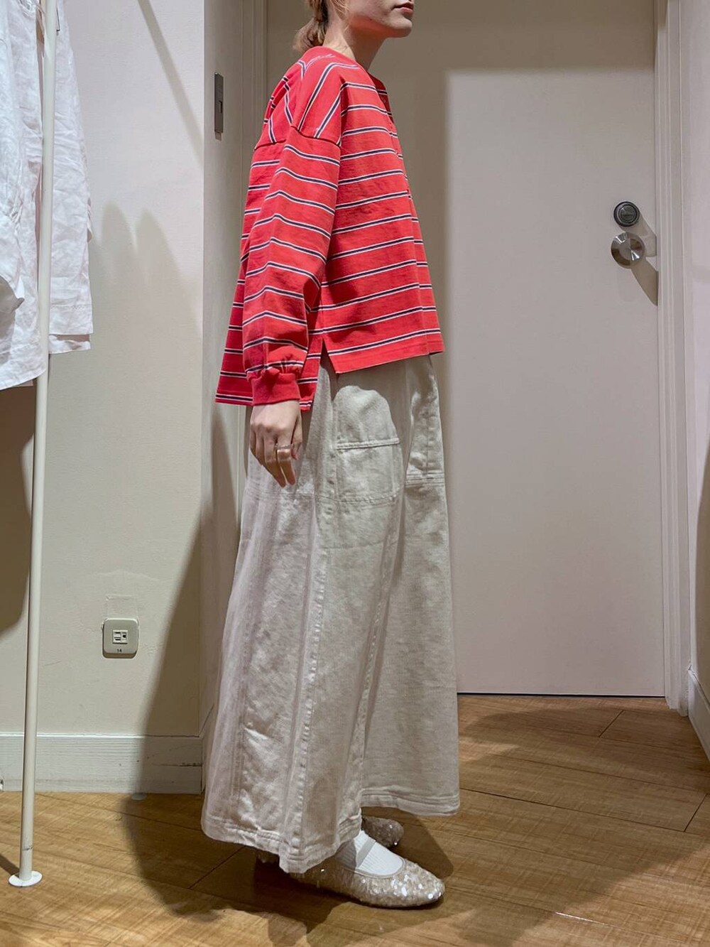 レッド系のTシャツ/カットソー、ホワイト系のバレエシューズ、ベージュ系のカーディガン/ボレロを着用したレディースの春コーディネートの7枚目の写真