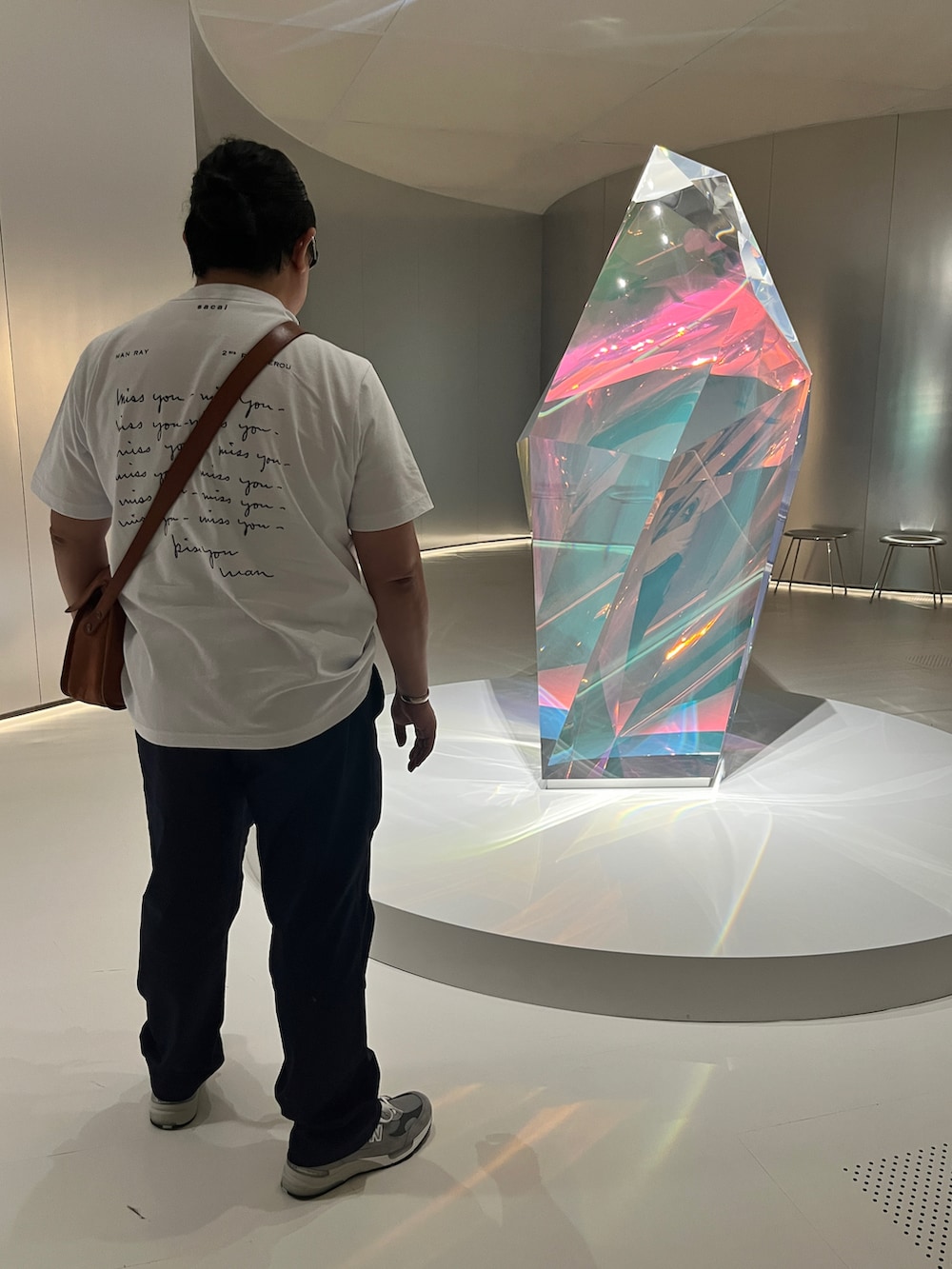 ホワイト系のTシャツ/カットソー、オレンジ系のショルダーバッグ、ブルー系のその他パンツを着用したメンズの秋コーディネートの2枚目の写真