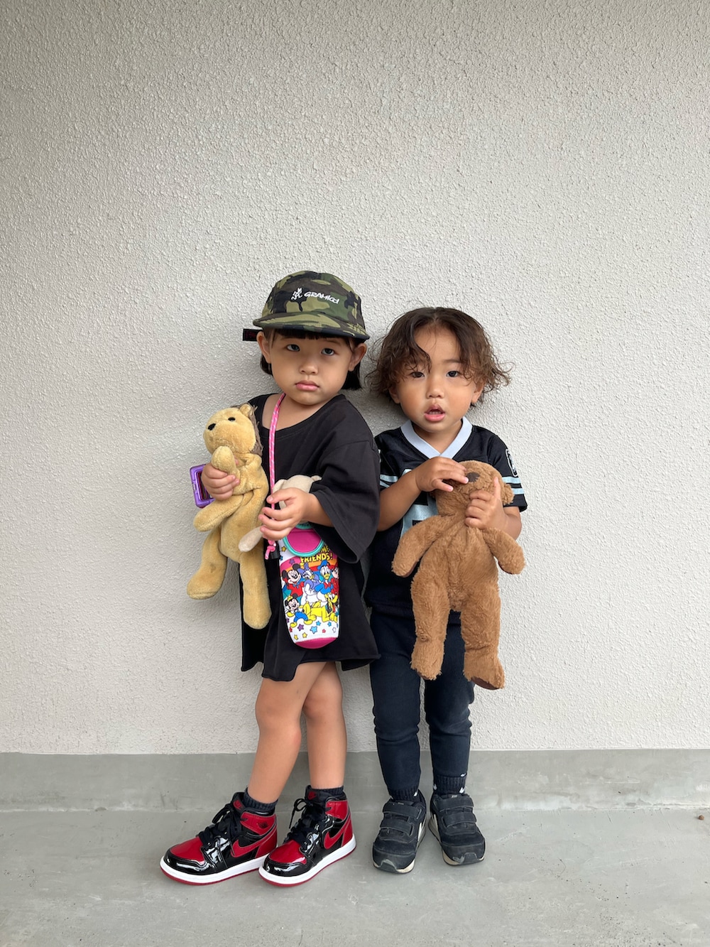 ブラック系のパンツ、ブラック系のシューズ、レッド系のスニーカーを着用したキッズの夏コーディネートの2枚目の写真