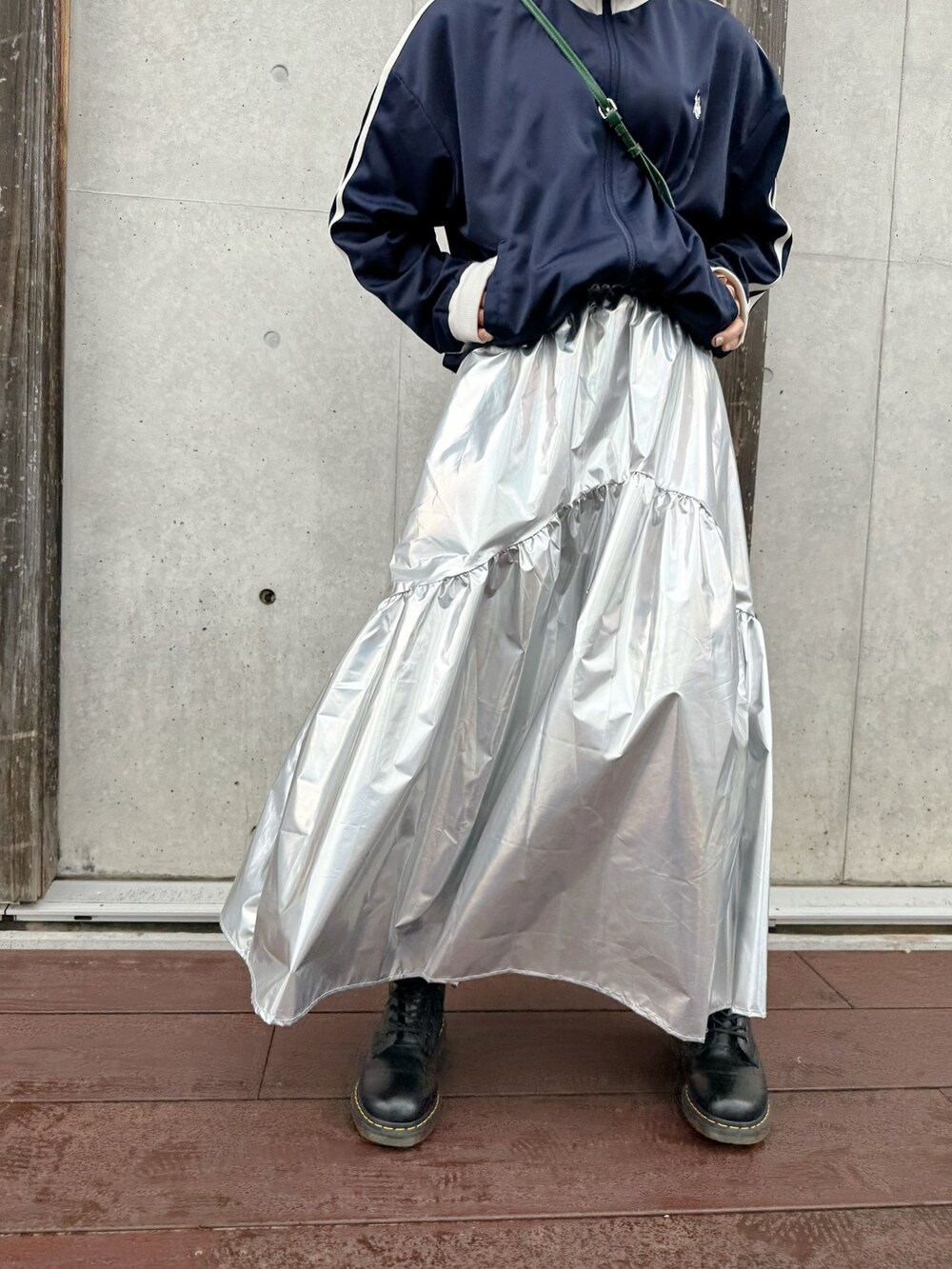 シルバー系のスカート、ブルー系のジャージ、ブラック系のブーツを着用したレディースの冬コーディネートの2枚目の写真