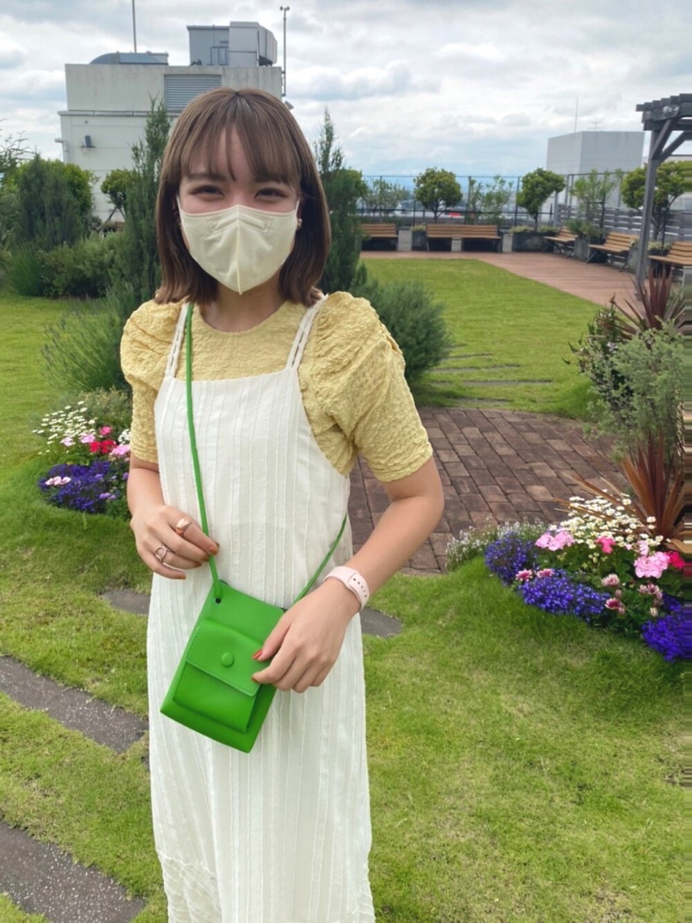 ホワイト系のワンピース、イエロー系のシャツ/ブラウス、グリーン系のショルダーバッグを着用したレディースの夏コーディネートの2枚目の写真