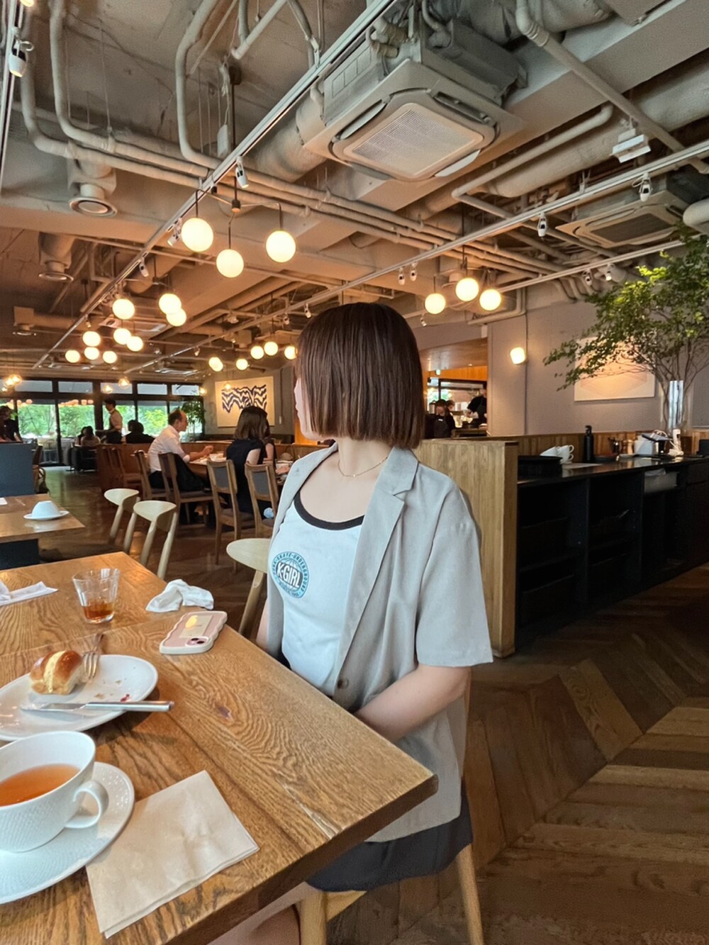 ホワイト系のキャミソール、グレー系のスカート、ブラック系のスウェットを着用したレディースの夏コーディネートの2枚目の写真