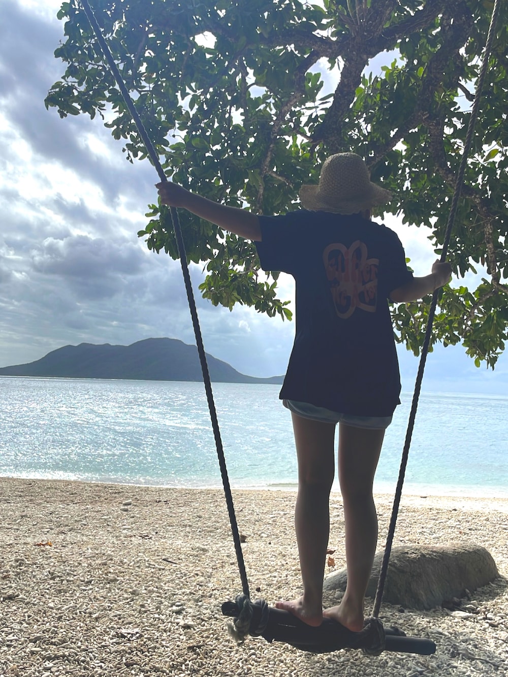 ブラック系のTシャツ/カットソー、ブラック系のサンダル、ベージュ系の帽子を着用したレディースの春コーディネートの2枚目の写真