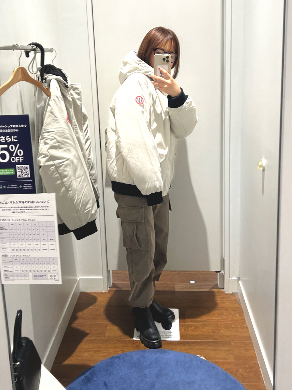 ホワイト系のジャケット/アウター、グリーン系のカーゴパンツ、ブラック系のメガネを着用したレディースの秋コーディネートの2枚目の写真