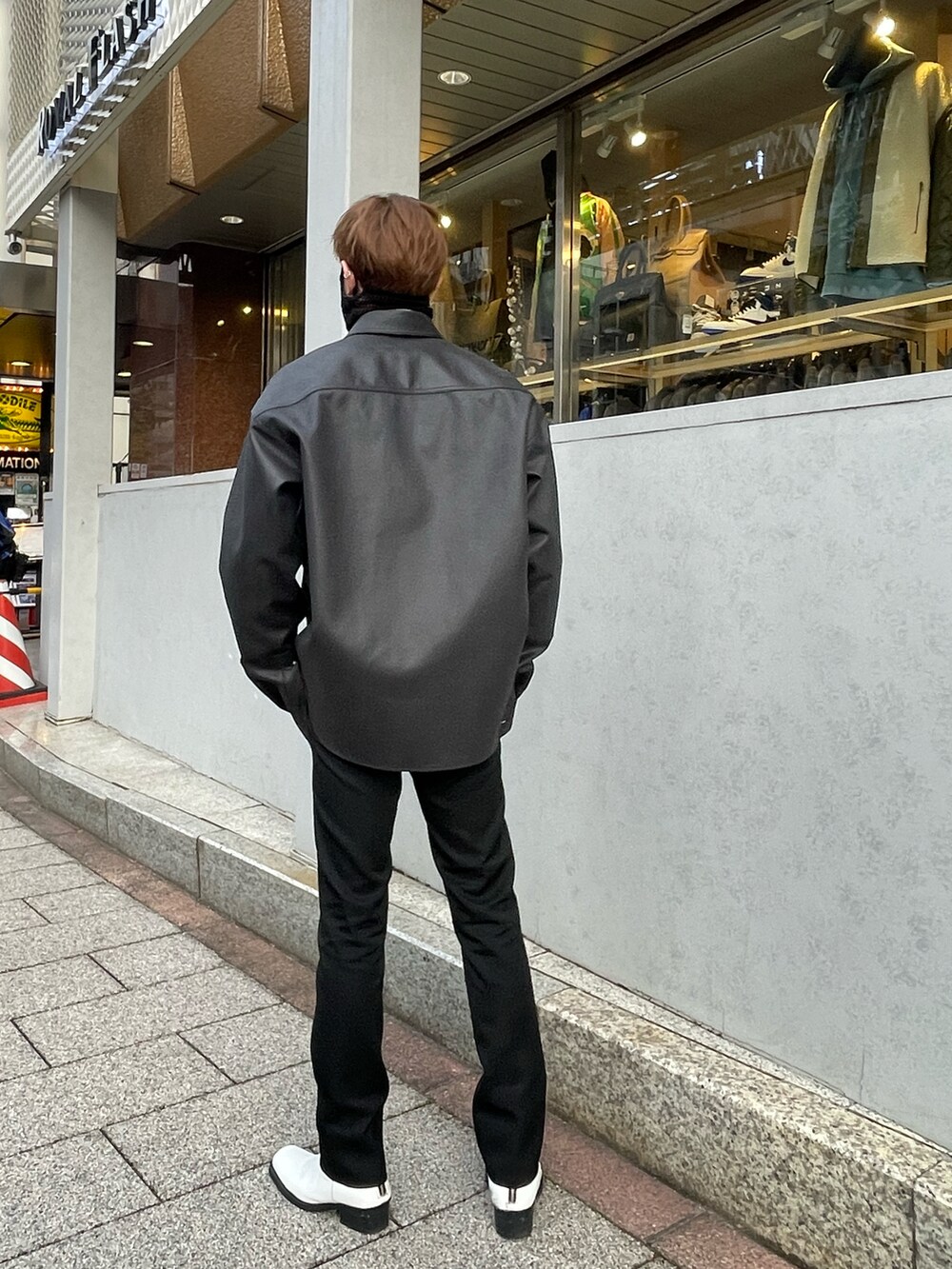 ブラック系のその他アウター、ブラック系のTシャツ/カットソー、ブラック系のスラックスを着用したメンズの冬コーディネートの2枚目の写真