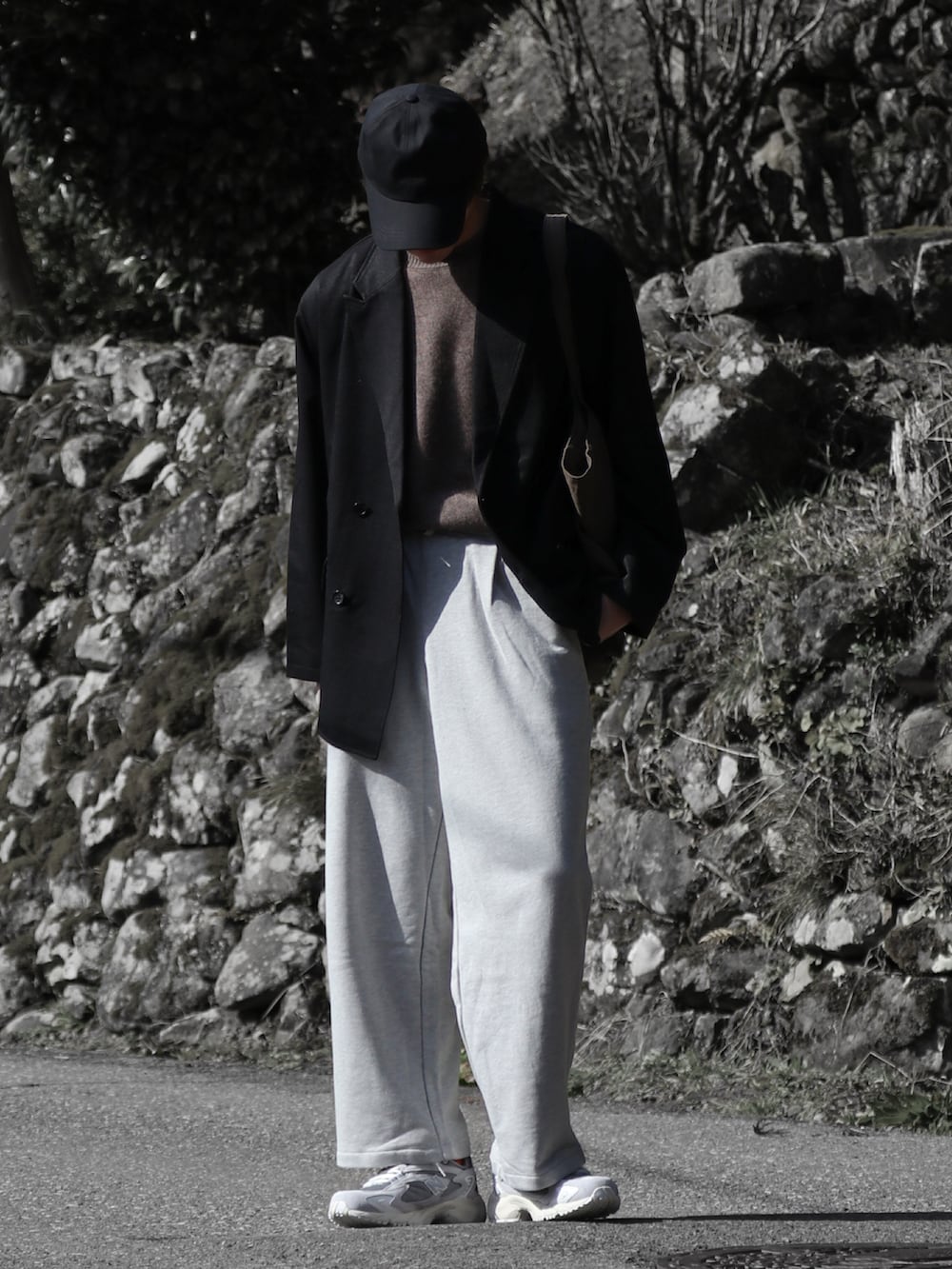 グレー系のスウェットパンツ、ブラック系のテーラードジャケット、ベージュ系のニット/セーターを着用したメンズの春コーディネートの3枚目の写真