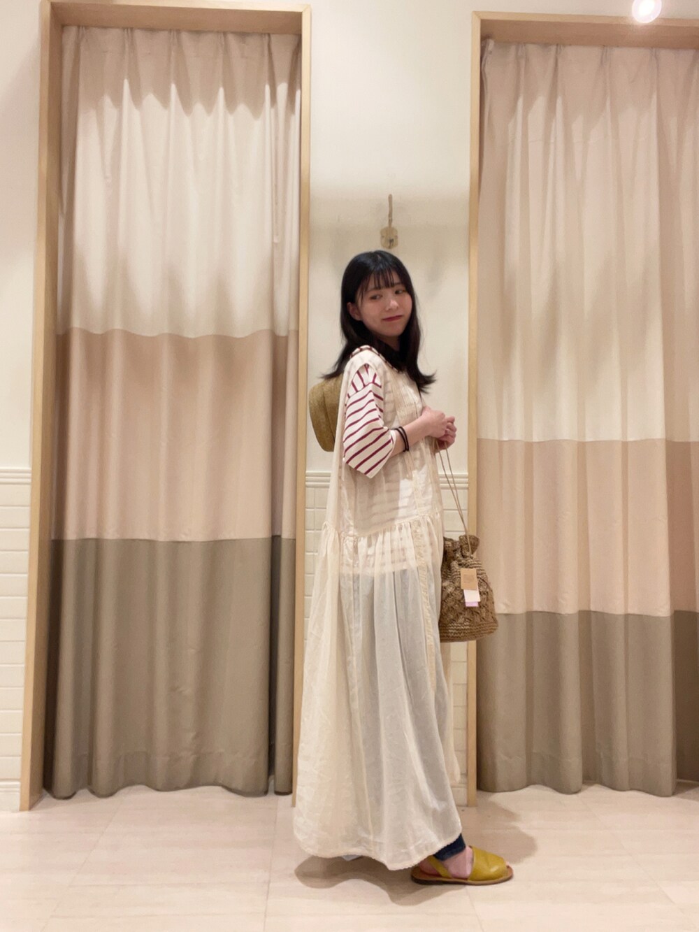 イエロー系のサンダル、ベージュ系のエコバッグ/サブバッグ、レッド系のトップスを着用したレディースの夏コーディネートの2枚目の写真