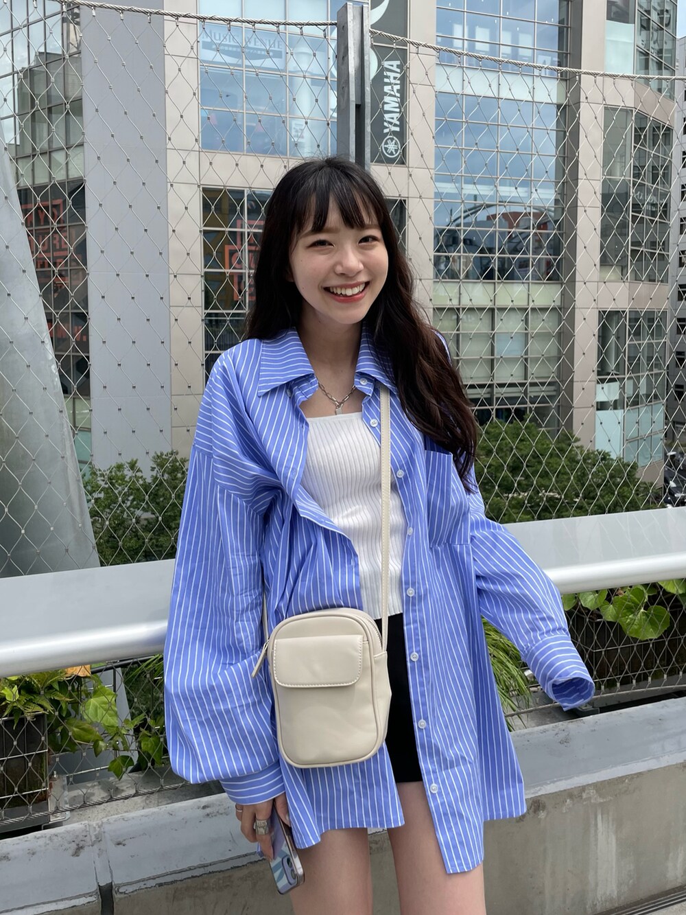 ホワイト系のキャミソールを着用したレディースの夏コーディネートの4枚目の写真