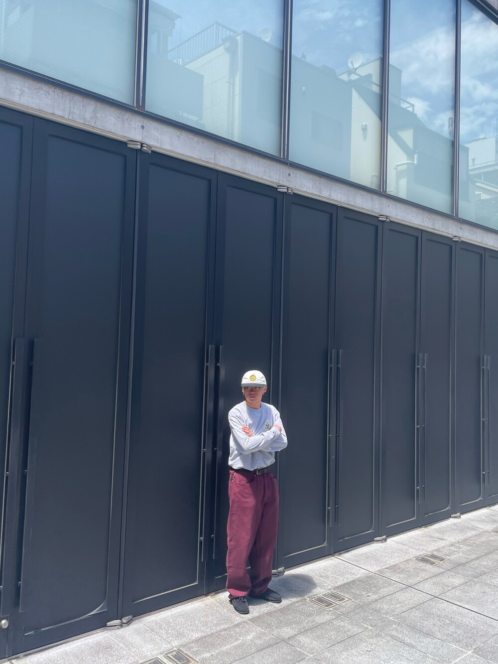 グレー系のTシャツ/カットソー、レッド系のデニムパンツ、ブラック系のモカシン/デッキシューズを着用したメンズの夏コーディネートの2枚目の写真